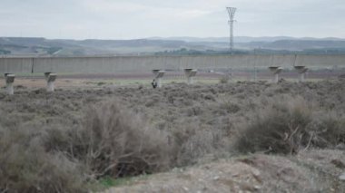 Uzakta bir köprünün yanında iki avcı - 4K Yatay video