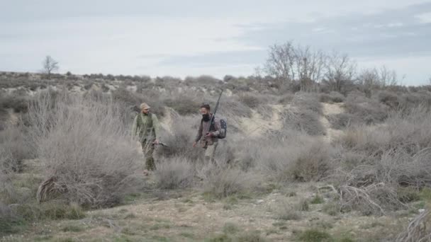 Zwei Erwachsene Jäger Mit Gewehren Laufen Durch Die Landschaft Horizontalvideo — Stockvideo