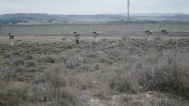 Bir köprünün yanında iki avcı Aragon 'da yürüyor - 4K Yatay Video