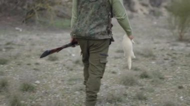 Beyaz gelincik taşıyan tanımlanamayan bir avcı - 4K Yatay video