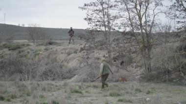 Bir avcı, köpeğin getirdiği tavşanı yakalar - 4K Yatay video