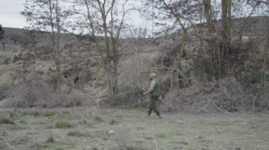 Yakınlarda yürüyen iki avcı ve bir köpek - 4K Yatay Video