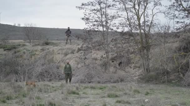 Ein Jäger Geht Mit Seinem Begleiter Und Einem Hund Der — Stockvideo