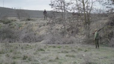 İki avcı dağ gelinciğinin tavşanları yuvadan çıkarmasını bekliyor - 4K Yatay video