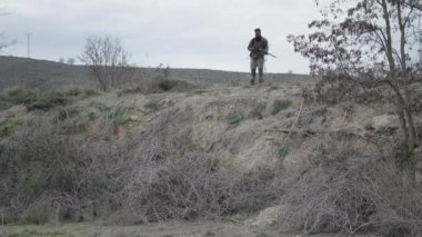Yerde bir şey arayan bir köpek ve bir avcı - 4K Yatay Görüntü