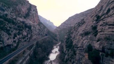 Dağlar arasında nehir boyunca uzanan bir tünel - yatay 4K video