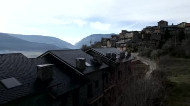 İnsansız hava aracı bazı dağ evlerinin çatısından geçiyor - 4K Yatay video