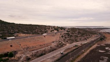 Araçlar gölün yanındaki yolda gidiyor - 4K Yatay Video