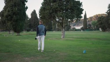 Tanımlanamayan bir çocuk golf sahasında yürüyor - 4K Yatay Video