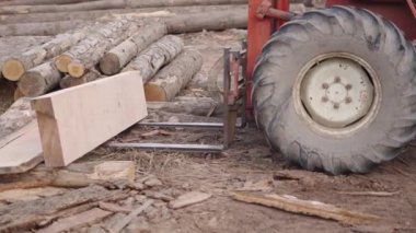 Bir operatör traktör kaldırma ile bir tahta parçası aldı - 4K yatay video