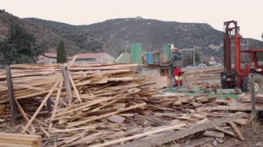 Bir yığın kerestenin arasında tanınmayan bir adam iş başında - 4K Yatay video