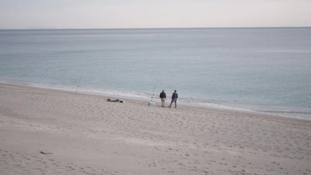Два Неузнаваемых Рыбака Ждут Пляже Горизонтальное Видео — стоковое видео