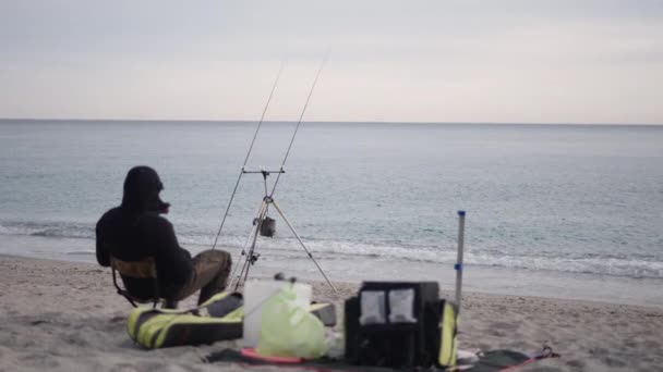 Pescador Sentado Areia Espera Peixe Horizontal Vídeo — Vídeo de Stock