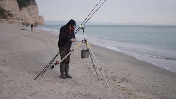 Ένας Ψαράς Προσαρμόζει Την Πετονιά Τους Ανθρώπους Στο Παρασκήνιο Οριζόντια — Αρχείο Βίντεο