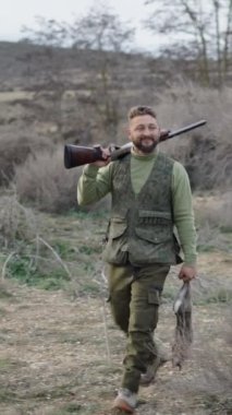 Tüfekli ve tavşanlı Kafkas avcısı FullHD dikey video