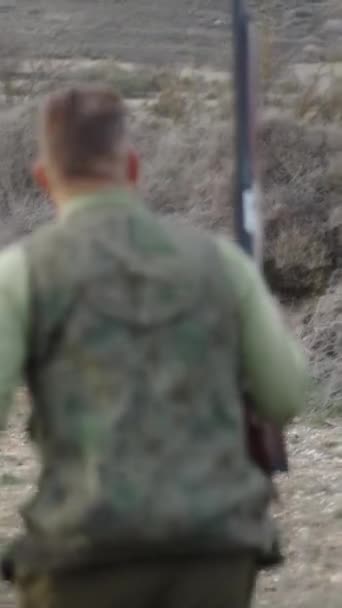 Ein Jäger Geht Rückwärts Mit Einem Gewehr Und Einem Kaninchen — Stockvideo