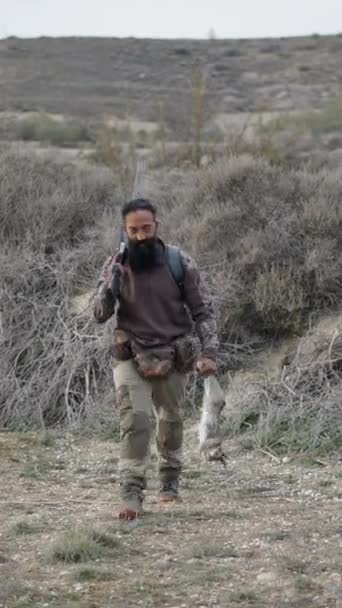 Ein Jäger Mit Einem Gewehr Und Sein Kaninchen Nähern Sich — Stockvideo