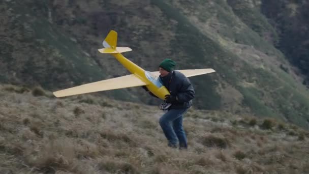 Ένας Άνθρωπος Παίρνει Αεροπλάνο Του Και Ανεβαίνει Λόφο Οριζόντια Βίντεο — Αρχείο Βίντεο