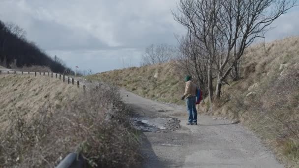 Een Bergweg Trekt Een Man Zijn Rugzak Uit Horizontale Video — Stockvideo