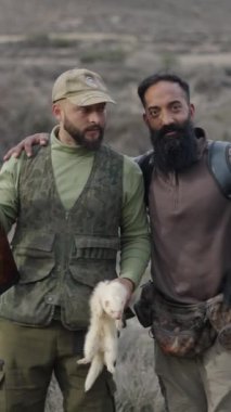 İki İspanyol avcı av tavşanı ve bir gelincik ile poz veriyor.