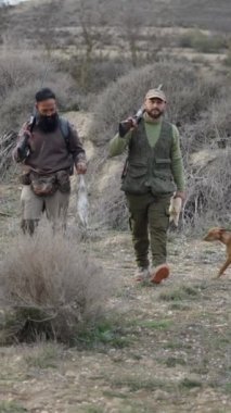İki avcı bir köpek ve yaya bir gelincik - FullHD dikey video
