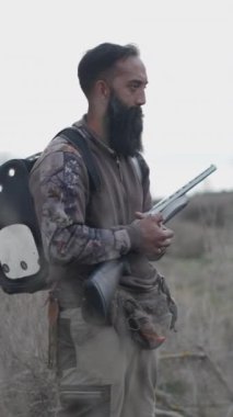 Uzun sakallı bir avcı avı FullHD dikey video ile vuruyor.