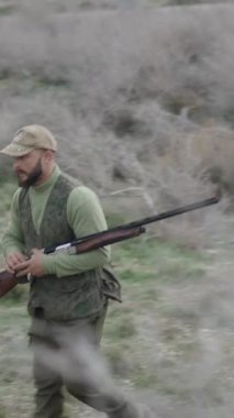 Elinde av tüfeği olan bir avcı, FullHD dikey video hakkında yorum yapıyor.