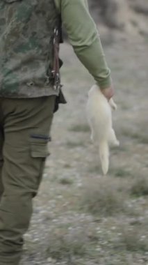 Beyaz gelincik taşıyan tanınmayan bir avcı FullHD dikey video