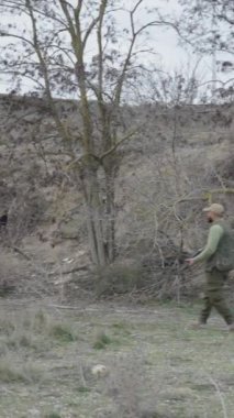 Yakınlarda yürüyen iki avcı ve bir köpek - FullHD dikey video