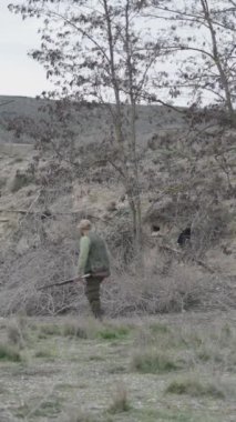 Yuvada iki avcıyla dolaşan bir köpek - FullHD dikey video
