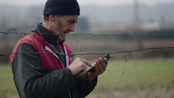Seorang Tukang Kebun Kulit Putih Melihat Sesuatu Smartphone Nya Horizontal — Stok Video