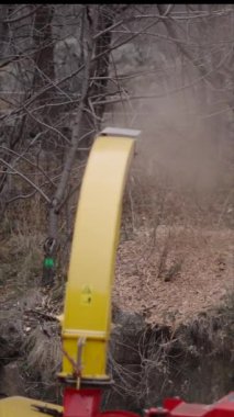 Bir makine çalılığa talaş fırlatır - FHD dikey video