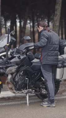Beyaz bir adam motosikletinden kickstand kaldırır FullHD dikey video