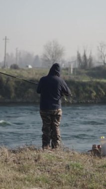 Tanınmayan bir balıkçı oltasını nehre atar - FHD Dikey