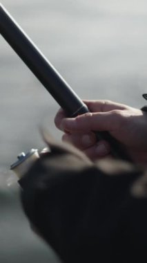 Bir balıkçının elleri oltanın ipini çözüyor - FHD Dikey