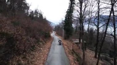 Dağ yolunda bir motosiklet var. 4K yatay video.