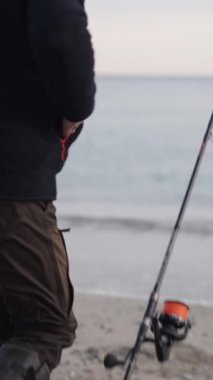 Tanınmayan bir balıkçı oltasının ucunu düzeltir FullHD dikey video