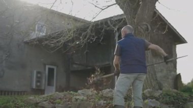 Bahçıvan kuru yaprakları temizler - yatay 4K