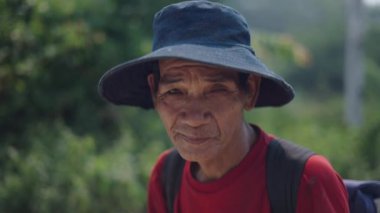 Olgun bir Asyalı Vietnamlı çobanın portresi. Şapkalı ve sırt çantalı. 4K yatay video.