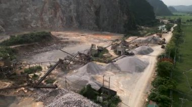 Hanoi Vietnam 'da minerallerin mikronizasyon için çıkarıldığı büyük dağların eteklerindeki çimento fabrikası - 4K Yatay Video