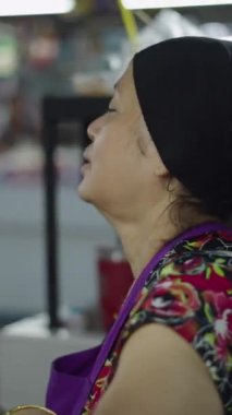 Olgun bir kadın oturmuş, rahatça sohbet ediyor ve rahatlatıcı bir anda, FullHD dikey video