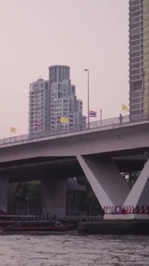 Bangkok Thathand 'daki Chao Reynaya nehri şehrin ufuk çizgisi FullHD Dikey Köprüsü' nün altında çok sayıda tekne taksisiyle dolanıyor.