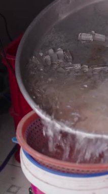 Yetişkin bir Asyalı kadının Vietnam 'daki Ho Chi Minh City caddesindeki tezgahında taze balık için buz hazırlaması ağır çekimde.