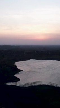 İnsansız hava aracı Vietnam 'da alacakaranlıkta Long Thanh Gölleri' nin büyük düz ormanları ve gölleri üzerinde uçuyor.