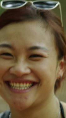 Vietnam 'da ormanda yürürken kameraya gülümseyen Vietnamlı bir kızın ağır çekim portresi.