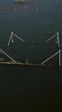 İnsansız hava aracı, Vietnam Gölü 'nün üzerinde uçuyor. Gölün ortasındaki balık ağları üzerinde. FullHD dikey.