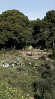 Motosikletlinin motosikletinin yanında durduğu küçük bir dağın panoramik görüntüsü FullHD dikey