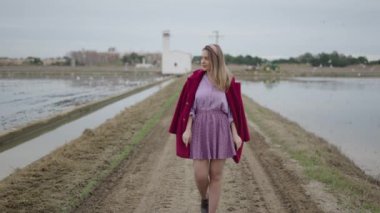 Mor giyinmiş bir kadın kameraya yaklaşıyor - 4K Yatay
