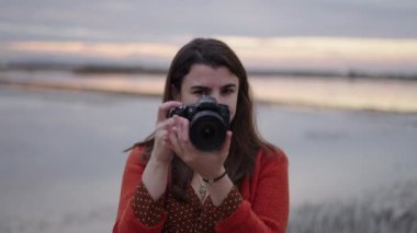 Kamerasını 4K Yatay Konuya çeviren bir kadın fotoğrafçının yakın çekimi.
