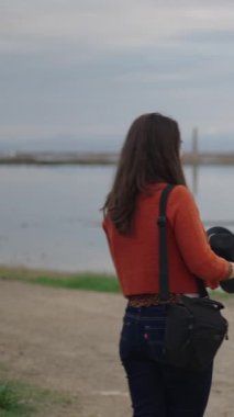 Fotoğrafçı model için bir şapka seçer ve FullHD dikey fotoğrafını çeker.